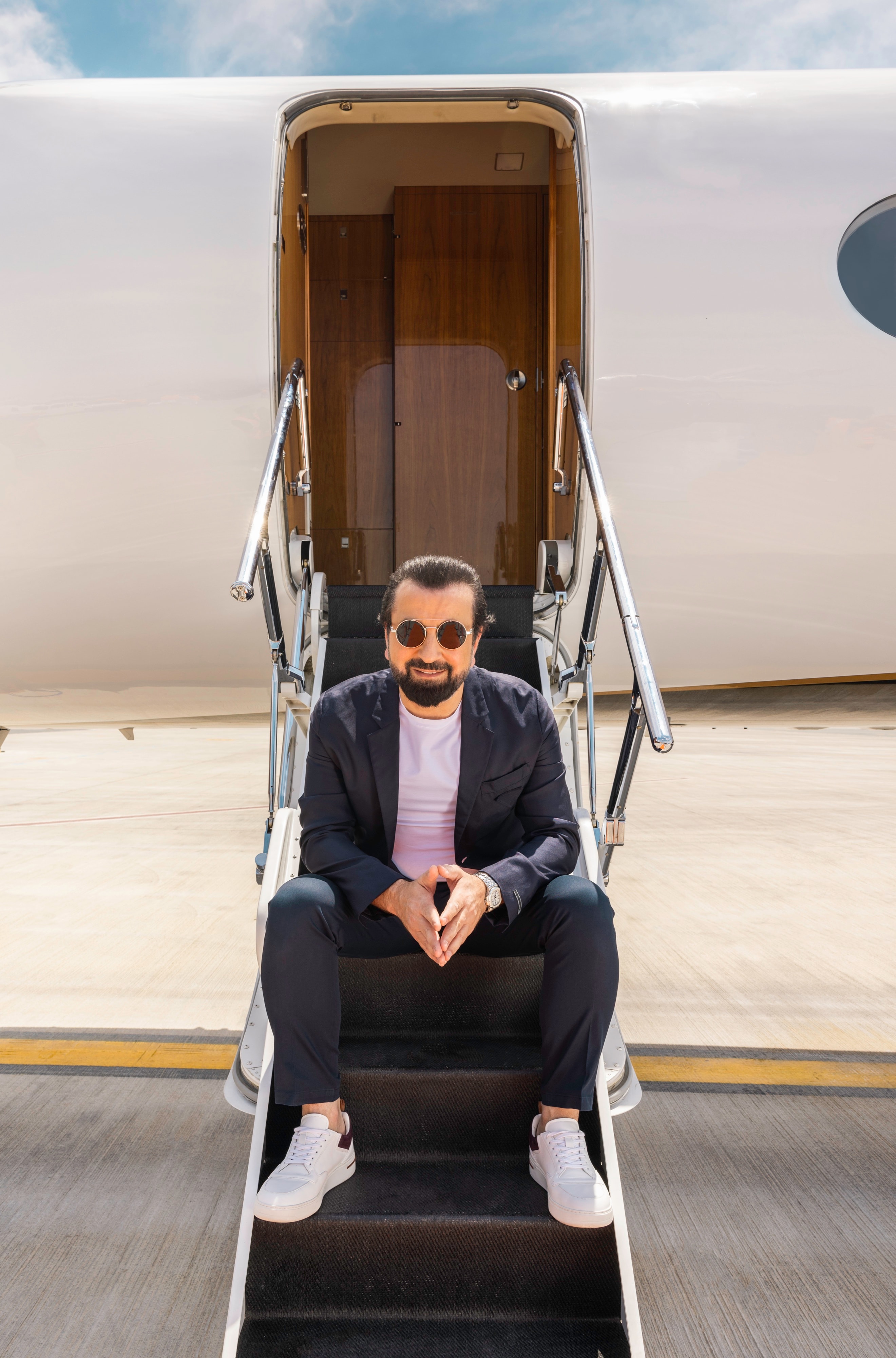 Adel Mardini seated on the airstair of a private jet in Dubai, 2023