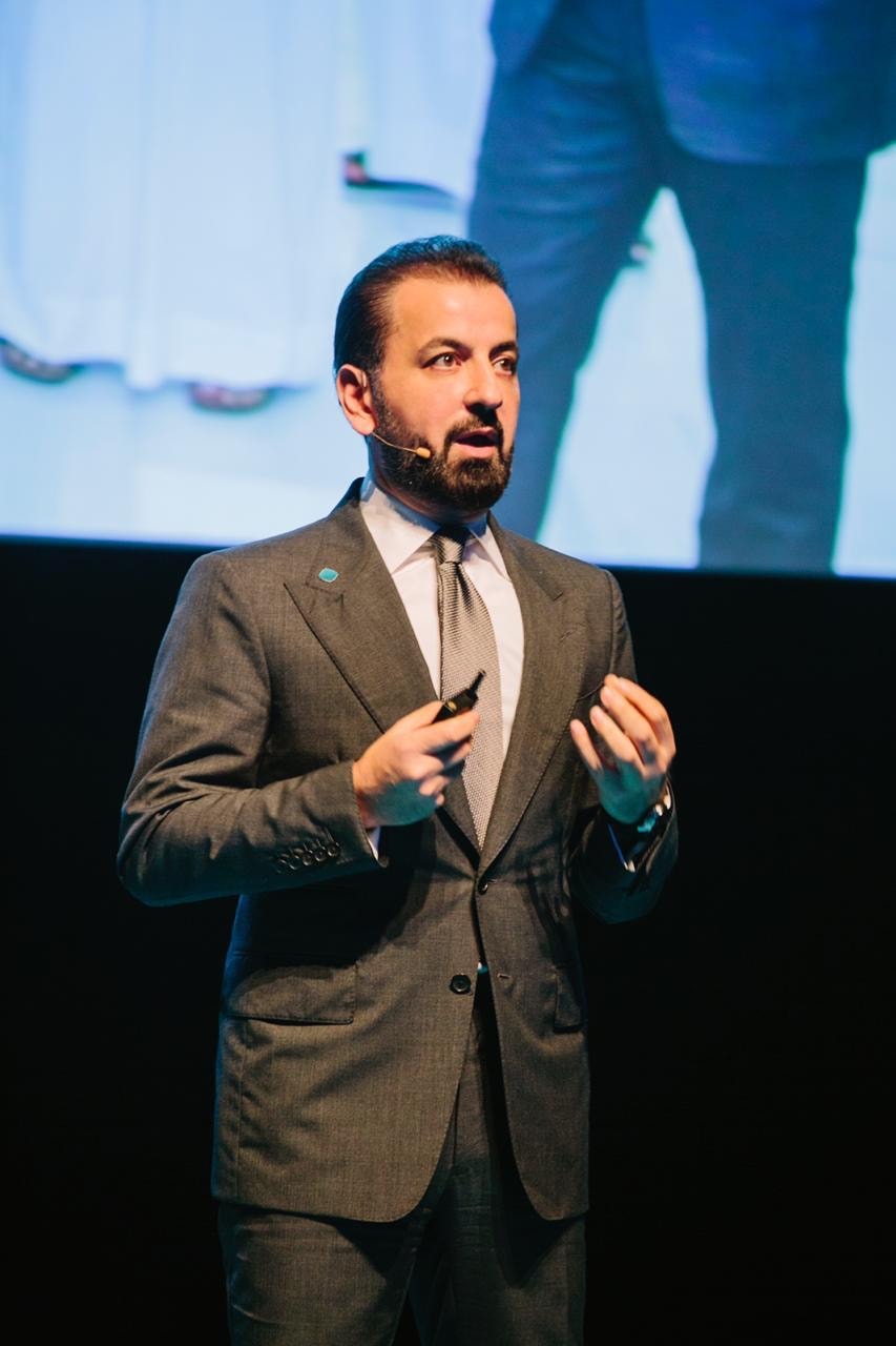 Adel Mardini speaking on stage at a conference