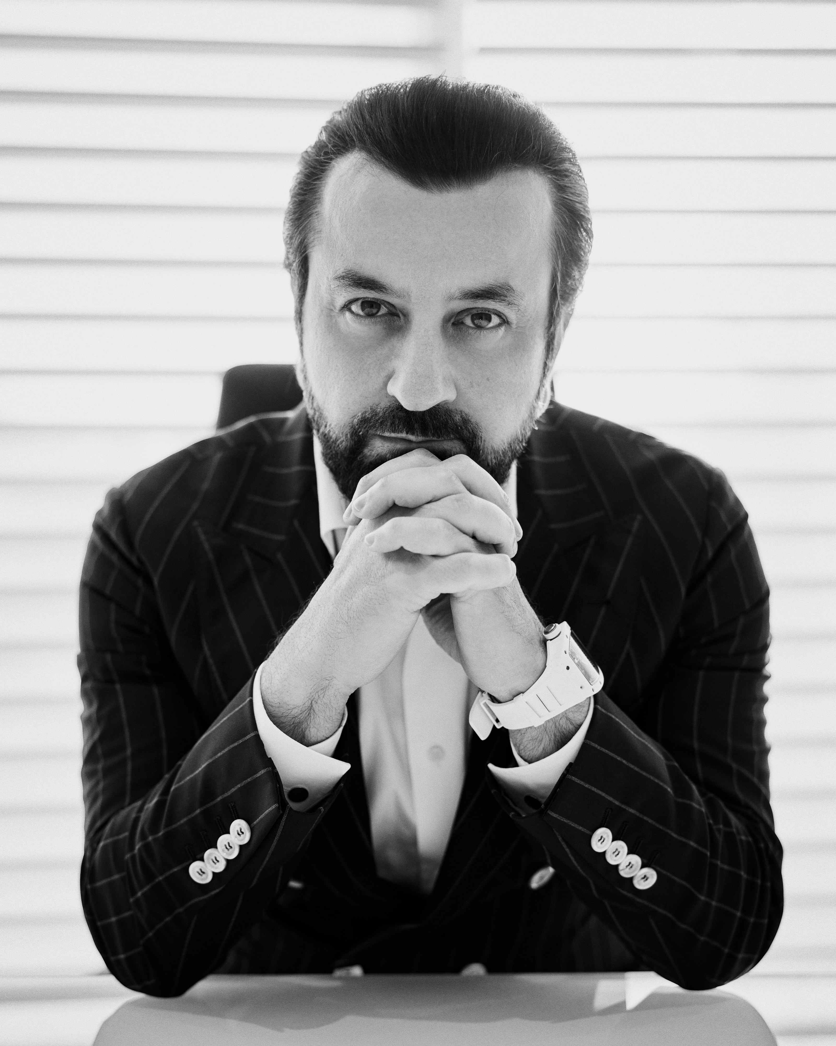 Black and white portrait of Adel Mardini, hands steepled, Abu Dhabi, 2025